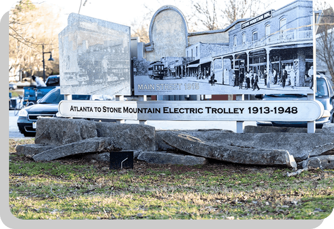 A sign that says atlanta to stone mountain electric trolley 1 9 1 3-2 0 1 8.