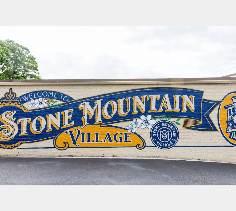 A sign for stone mountain village on the side of a building.